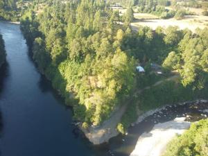an aerial view of a river with trees and a house at camping los hualles in Lago Ranco