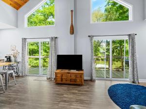 a living room with a flat screen tv and windows at Jax Joint - Pet Friendly - Perfect Family Vacation Spot! in Crane Hill