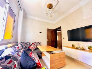 a living room with a couch and a flat screen tv at Dar La Madina Essaouira in Essaouira