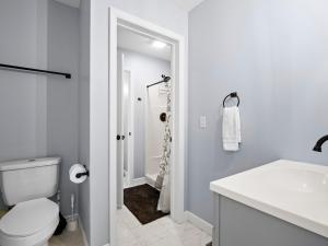a white bathroom with a toilet and a sink at Jax Joint - Pet Friendly - Perfect Family Vacation Spot! in Crane Hill +20 photos