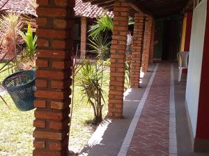 a brick wall next to a porch with a cat on it at Pousada Taba de Canes in Canavieiras +32 photos