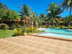 a resort with a swimming pool and palm trees at Pousada Taba de Canes in Canavieiras