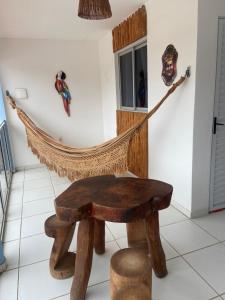 a hammock chair in a room with a mask on the wall at Luar Dos Milagres in São Miguel dos Milagres