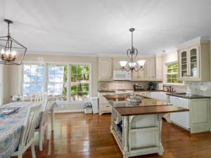 a kitchen with white cabinets and a dining room with a table at Sheltered Cove - Family-Friendly With Lots Of Options! in Jasper