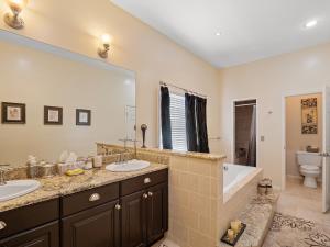 a bathroom with two sinks and a tub and a toilet at Rocking W - Screened In Porch And Lakeside Fire Pit! in Double Springs +22 photos