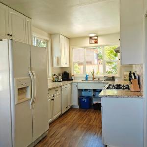 a kitchen with white appliances and wooden floors at Saltwater Beach Home with Ocean View in Des Moines