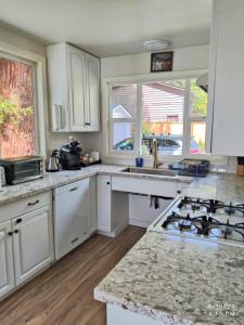 a kitchen with white cabinets and granite counter tops at Saltwater Beach Home with Ocean View in Des Moines +28 photos