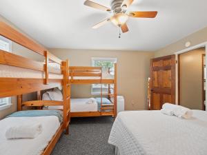 a bedroom with two bunk beds and a ceiling fan at Carols Cottage - Double Decker Dock! Popular Location! in Cullman