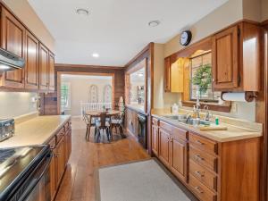 a kitchen with wooden cabinets and a dining table at Carols Cottage - Double Decker Dock! Popular Location! in Cullman +29 photos