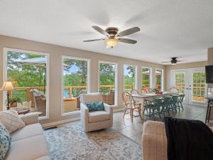 a living room with a ceiling fan and a table and chairs at Carols Cottage - Double Decker Dock! Popular Location! in Cullman