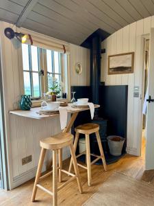 a kitchen with a table and stools in a room at The Hut at Claston in Stoke Edith +12 photos