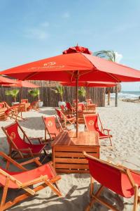 a group of chairs and an umbrella on the beach at Luxury Suite frente de Mar Piscina Restaurante y Bar in San Silvestre