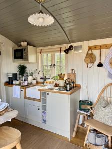 a kitchen with white cabinets and a counter top at The Hut at Claston in Stoke Edith