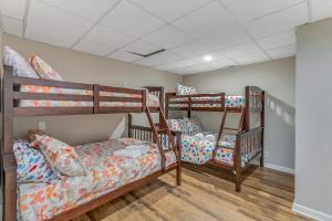 three bunk beds in a room with wooden floors at Yellowhammer Hill - Amenities Galore! Near Cullman in Cullman +31 photos