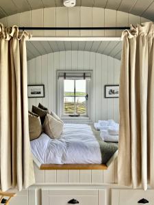 a bed in a room with a window at The Hut at Claston in Stoke Edith