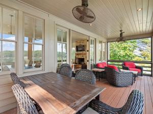 a screened in porch with a wooden table and chairs at Central Perk - Pet Friendly, Luxury Cabin Feel, Kayaksand Coffee! in Crane Hill