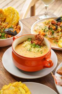 a bowl of soup on a table with plates of food at Luxury Suite frente de Mar Piscina Restaurante y Bar in San Silvestre