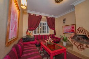 a living room with red furniture and a red table at Mumtaz Dar in Marrakesh