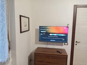 a flat screen tv sitting on top of a wooden dresser at Lo Studio in Pioltello