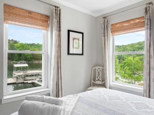 a bedroom with a bed and two large windows at Cranes Nest - Huge Dock With Two Kayaks For The Guest's Use! in Crane Hill