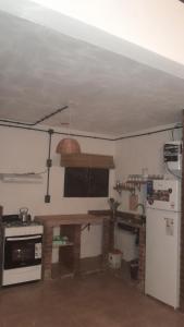 a kitchen with a table and a refrigerator at Los Almendros in Nueva Atlantis