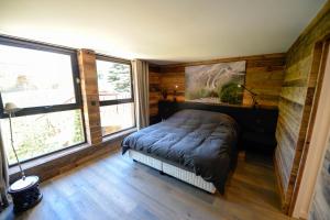 um quarto com uma cama num quarto com janelas em Chamonix Balcons du Mont Blanc em Chamonix-Mont-Blanc