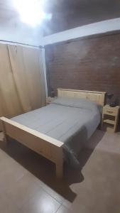 a wooden bed in a room with at Los Almendros in Nueva Atlantis