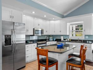 a kitchen with white cabinets and a stainless steel refrigerator at Blessings Family Lodge- Amazing Sunsets, Amazing Views! in Houston +22 photos