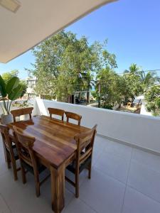 a wooden table and chairs on a balcony at Mykonos Beach House Apartamentos By Jerusalema in Tolú