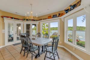 a dining room with a table and chairs and windows at Lake Therapy - Gazebo On The Lake, Easy Walk To The Water! in Crane Hill