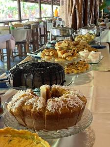 a table topped with different types of cakes and pastries at Pousada Taba de Canes in Canavieiras