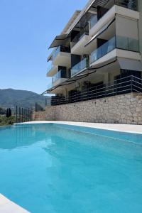 a swimming pool in front of a building at 3L Apartment and Studio in Nikiana