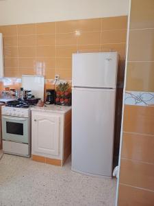 a kitchen with a white refrigerator and a stove at Maryline house in Bizerte