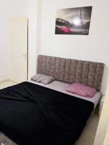 a bed with two pink pillows on top of it at Maryline house in Bizerte