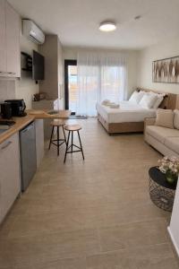 a kitchen and a living room with a couch and a bed at 3L Apartment and Studio in Nikiana
