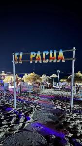 a sign on a beach with chairs and umbrellas at Maryline house in Bizerte