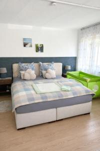 a bedroom with a large bed with two stuffed animals on it at Apartment Messe Karlsruhe in Rheinstetten
