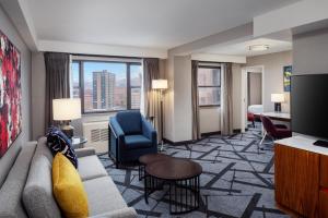 a living room with a couch and a chair in a hotel room at DoubleTree by Hilton Hotel & Suites Pittsburgh Downtown in Pittsburgh
