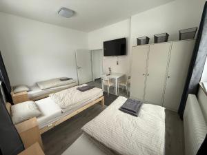 a small room with two beds and a table at Hostel & Monteurzimmer bei KuK in Hamburg +11 photos