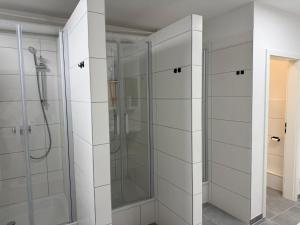 a bathroom with a shower and two glass shower stalls at Hostel & Monteurzimmer bei KuK in Hamburg