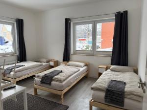 a room with three beds and two windows at Hostel & Monteurzimmer bei KuK in Hamburg