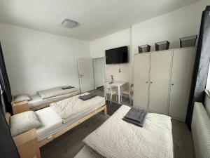 a small room with two beds and a table at Hostel & Monteurzimmer bei KuK in Hamburg