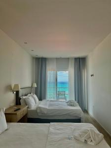 a hotel room with two beds and a view of the ocean at Horizon in Pefkochori