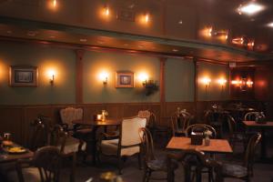 a dining room with tables and chairs and lights at Hotel Vento in Ventspils