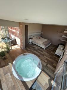 a bath tub in the middle of a room with a bed at Potre casas de montaña in Potrerillos