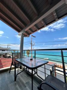 a table on a balcony with a view of the ocean at Horizon in Pefkochori