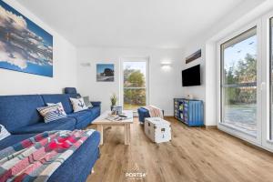 a living room with a blue couch and a table at Ferienhaus Ankerplatz St Peter-Ording in Böhl