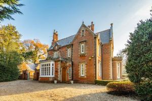 an old brick house with a large driveway at Bressingham Lodge by Leap Escapes in Diss