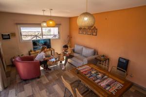 two people are sitting in a living room at Potre casas de montaña in Potrerillos