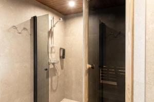 a bathroom with a shower with a glass door at Holiday Village Nuorgamin Lomakeskus in Nuorgam +73 photos